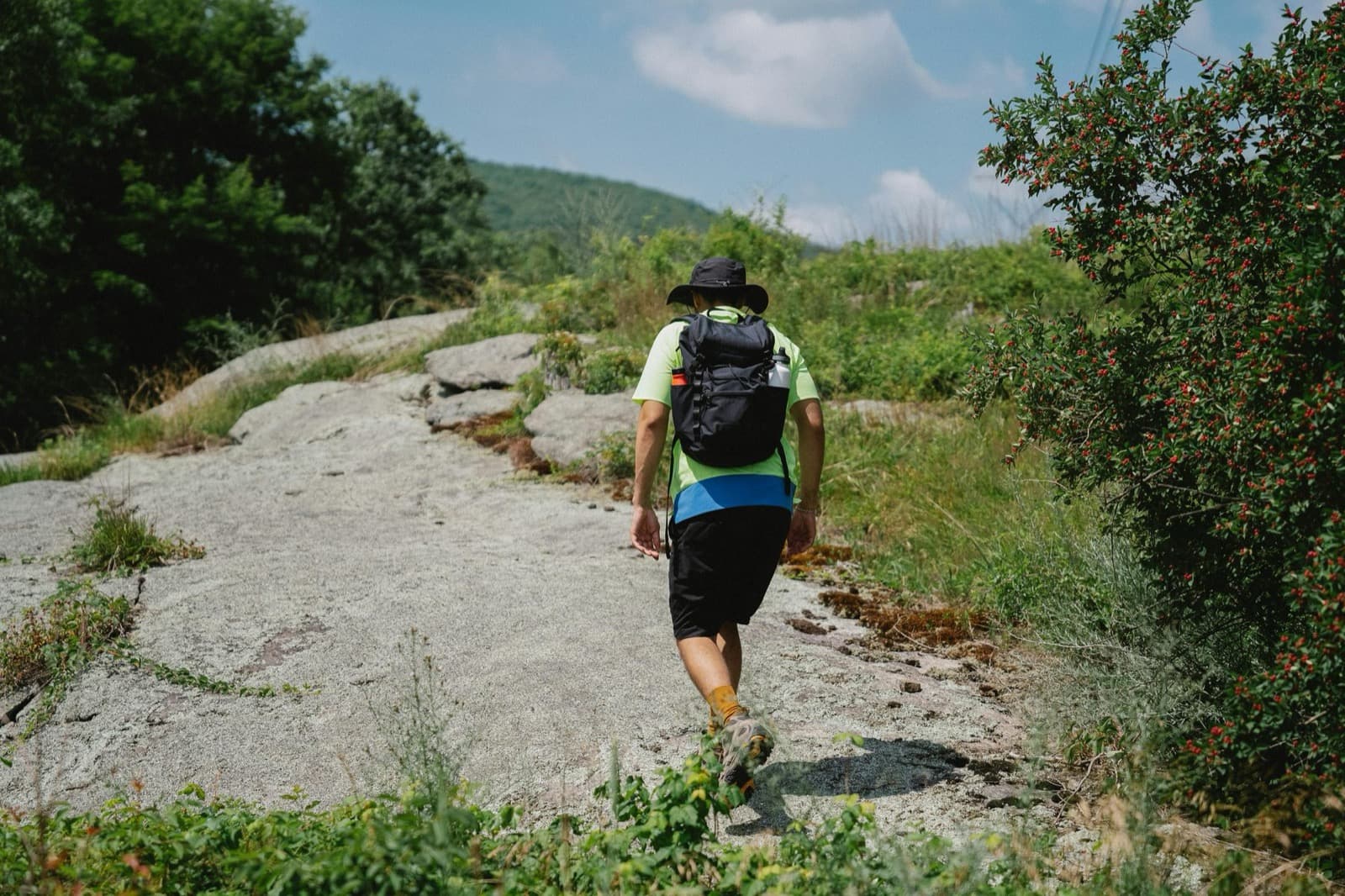 Backpacker on a rocky Appalachian Trail-style path with the Blue Ridge mountains in the distance